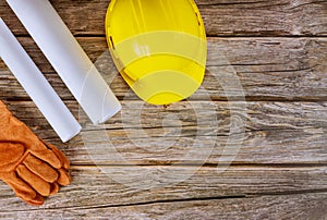 Builder of architects blueprints working on engineering office construction plans safety gloves on yellow hard hat