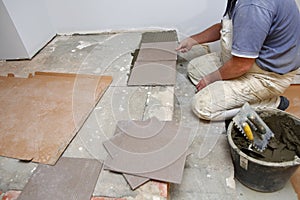 The builder arranges ceramic tiles on the stairs inside the building.