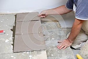 The builder arranges ceramic tiles on the stairs inside the building.