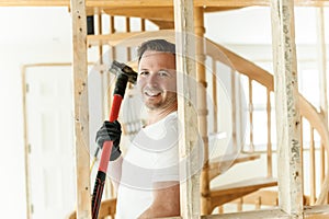 builder carpenter with sledge hammer hit a wall with frustration