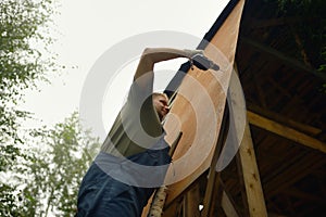 Builder or carpenter working and builds a roof