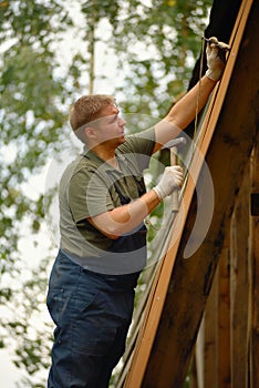 Builder or carpenter working and builds a roof