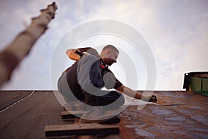 Builder or carpenter working on the roof