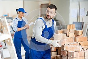 Builder carrying bricks while working in apartment