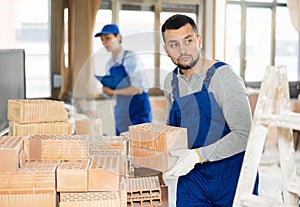 Builder carrying bricks while working in apartment