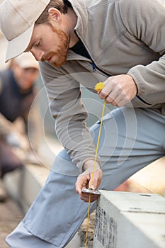 builder checking brick wall with spirit level