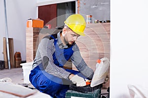 Builder is choosing tools in suitcase for work