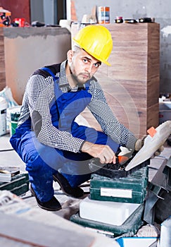 Builder is choosing tools in suitcase for work