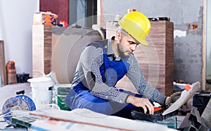 Builder is choosing tools in suitcase for work