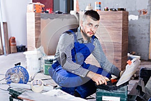 Builder is choosing tools in suitcase for work