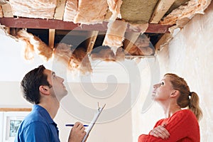 Builder And Client Inspecting Roof Damage