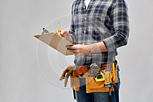 Builder with clipboard, pencil and working tools