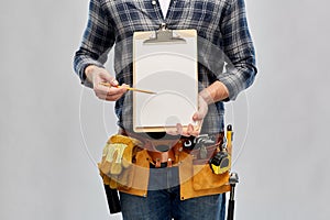 Builder with clipboard, pencil and working tools