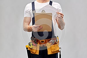 Builder with clipboard, pencil and working tools
