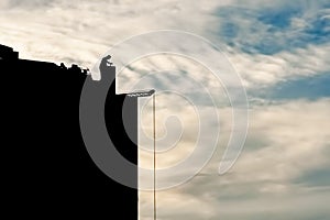 The builder at the construction site works at sunset