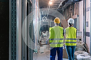 Builder and construction worker inspecting the site