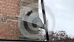 A builder in a container for supplying concrete solution, violating safety regulations, works at height