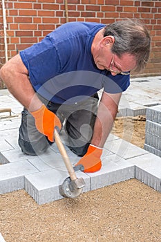 Builder or contractor laying paving stones.