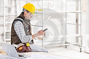 Builder or contractor using a mobile phone on site