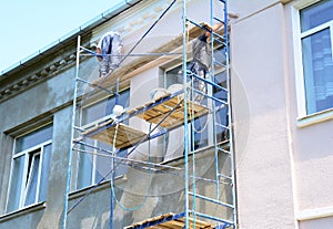 Builder contractors painting walls outside house facade. Close up on painting house outside wall during house renovation