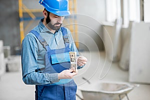 Builder with salary at the construction site photo