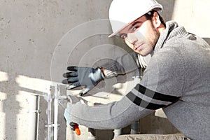 Builder cutting an outdoor pipe