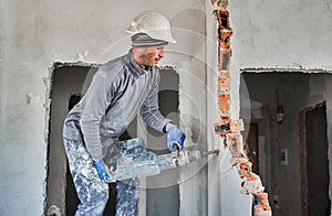 Builder destroying inner partition by jackhammer in apartment.