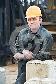 Builder in dirty workwear at construction site photo