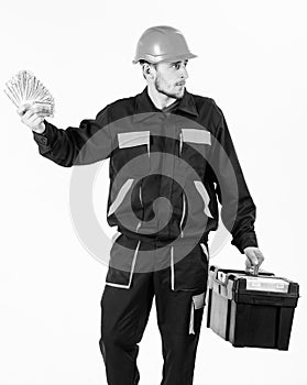 Builder earn money, repairman holds banknotes in hand. Payday concept. Man with toolbox got salary, money for work.