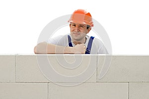 Builder erects a wall from a brick