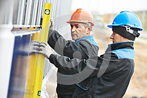 Builder facade plasterer worker with level photo
