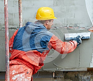 Builder at facade plastering works