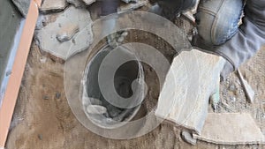 Builder faces the basement of a house with a wild stone. Flat for cladding, tabata on the construction site.