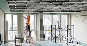 Builder fastens profile using cordless screwdriver