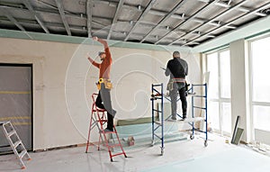 Builder fastens profile using cordless screwdriver