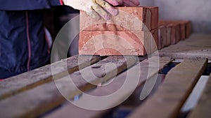 builder folds bricks, hands close up