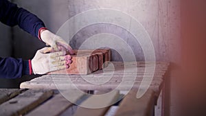 builder folds bricks, hands close up