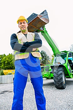 Builder in front of construction machinery