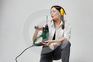 Builder girl holding a drill. concept of Housewives, working tools and construction work