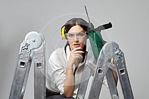 Builder girl holding a drill. concept of Housewives, working tools and construction work