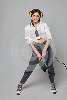 Builder girl holding a drill. concept of Housewives, working tools and construction work photo
