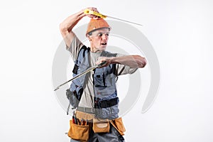 A builder with hacksaws in a helmet mocks. On a light background