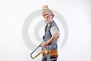 A builder with hacksaws in a helmet mocks. On a light background photo