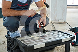 Builder with hammer in his hand and auto tools