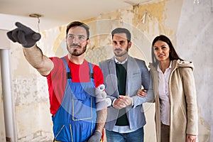 Builder handyman shows to young couple details about renovations