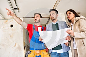 Builder handyman shows to young couple problem iin blueprints of