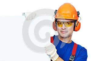 Builder in hard hat, earmuffs and goggles