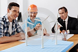 Builder in hard hat pointing at the wind turbine sail