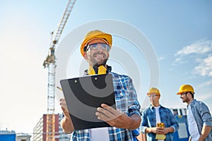 Builder in hardhat with clipboard at construction