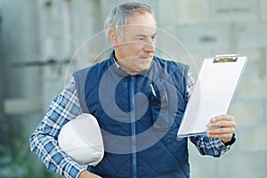 builder in hardhat with clipboard outdoors